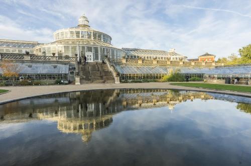 a large building with a pond in front of it at Beautiful Apartments on Strøget in Copenhagen City Center in Copenhagen