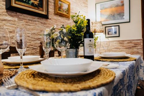 a table with a bottle of wine and glasses at Casa Rural los Enebros in Los Navalucillos
