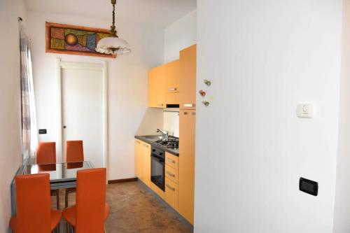 - une cuisine avec une table et des chaises orange dans l'établissement Casa margot, à Riva Ligure