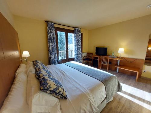 - une chambre avec un grand lit et une fenêtre dans l'établissement Hotel Saurat, à Espot