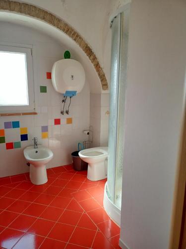 a bathroom with two toilets and a sink at La casetta in Pomarico