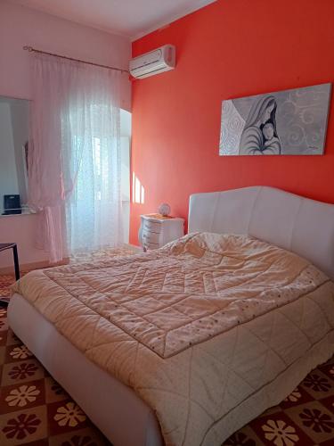 a bedroom with a large bed with an orange wall at La casetta in Pomarico
