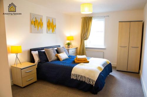 a bedroom with a blue and white bed and a window at Executive 2 Bed Flat in Stockton Heath by Amazing Spaces Relocations Ltd in Warrington