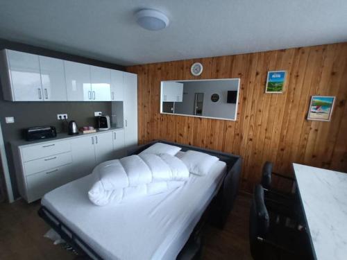 a bedroom with a bed with white pillows on it at STUDIO DE LA BICHETTE in Besse-et-Saint-Anastaise