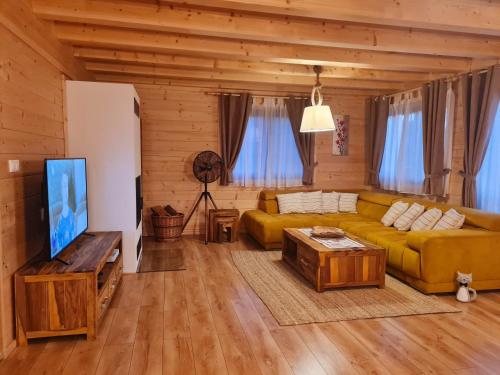 a living room with a couch and a tv at Panorama Tatry Chalets in Veľká Lomnica