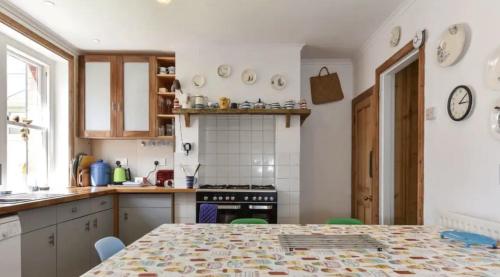 uma cozinha com uma mesa e um fogão forno superior em Solent Sea View beach Cottage em Hill Head