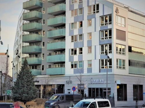 a tall building with cars parked in front of it at Demims Apartments Lillestrøm - Central location & Parking in Lillestrøm