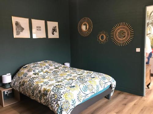 - une chambre avec un lit et des photos sur le mur dans l'établissement Dépendance de charme totalement rénovée, à Saint-Cast-le-Guildo