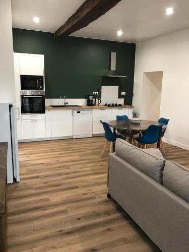 une cuisine et un salon avec un canapé et une table dans l'établissement Dépendance de charme totalement rénovée, à Saint-Cast-le-Guildo