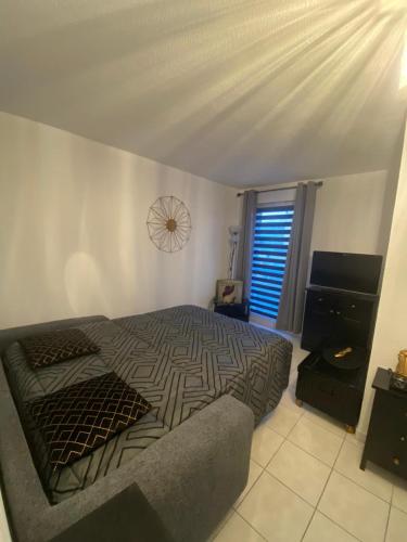une chambre avec un lit, un canapé et une fenêtre dans l'établissement Studio confort port de Frejus, à Fréjus