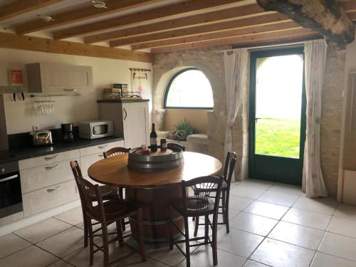 a kitchen with a wooden table and chairs in a room at Chai Crann Piorra 1 in La Valade