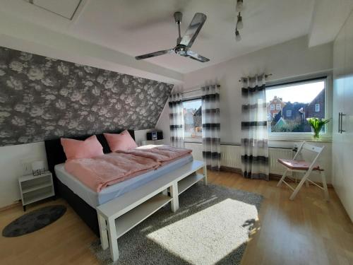 ein Schlafzimmer mit einem Bett und einem großen Fenster in der Unterkunft Ferienwohnung Mühlennest in Emden