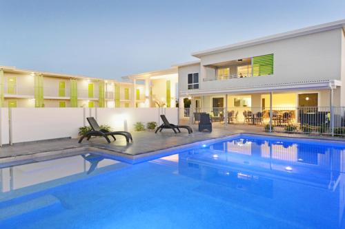 ein Swimmingpool vor einem Haus in der Unterkunft Mackay Oceanside Central Hotel Official in Mackay