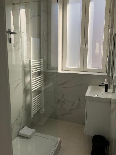 une salle de bain blanche avec une douche et un lavabo dans l'établissement Sainte Cécile 7 - T3 élégant et central, à Vichy