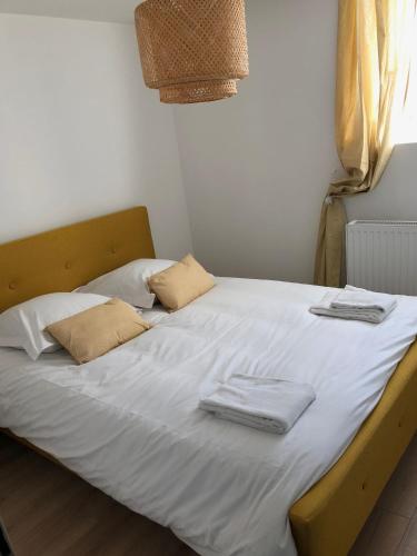 - un lit avec des draps blancs et 2 serviettes dans l'établissement Sainte Cécile 7 - T3 élégant et central, à Vichy