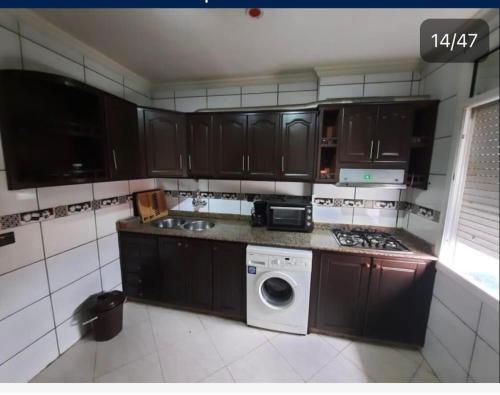 een keuken met een wasmachine en een vaatwasser bij Marchica Apartment Nador Jadid Wifi Klima in Nador