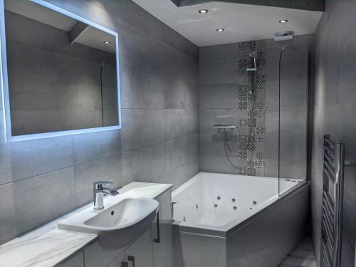 
a bathroom with a sink, toilet and bathtub at The Wildings Hotel & Tudno's Restaurant in Llandudno
