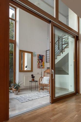 a glass door leading to a living room with a staircase at Laid Back Villa in Budapest