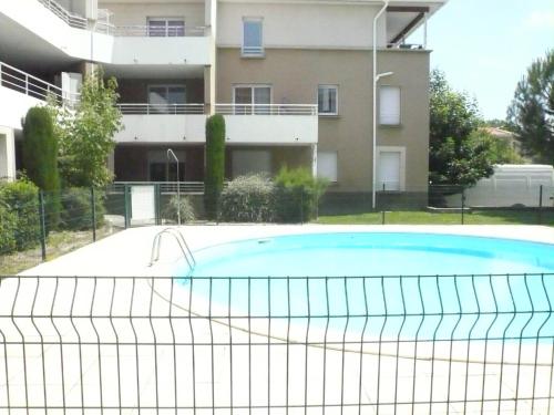 une piscine avec un filet de tennis en face d'un bâtiment dans l'établissement Tout confort ! Calme, Climatisation, Piscine, Parking Gratuit, Grande Terrasse, Netflix, Wifi, à Carcassonne