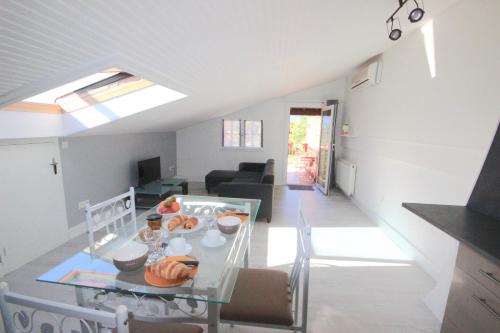 cocina y sala de estar con mesa de cristal en Gîte les Mimosas des orgues de la Sybille, en Ille-sur-Têt