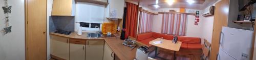 a small kitchen with a red couch in a train at Lodge Rabasquinha in Fronteira