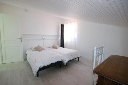 1 dormitorio con cama, ventana y mesa en Gîte les Mimosas des orgues de la Sybille, en Ille-sur-Têt