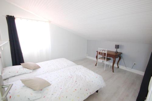 a bedroom with two beds and a desk and a window at Gîte les Lauriers des orgues d'Ille - la Sybille in Ille-sur-Têt