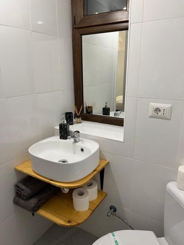 a bathroom with a sink and a mirror and a toilet at One Room Iasi in Iaşi