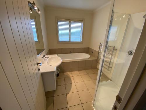 a bathroom with a tub and a sink and a shower at Sam's Place in Lake Tekapo