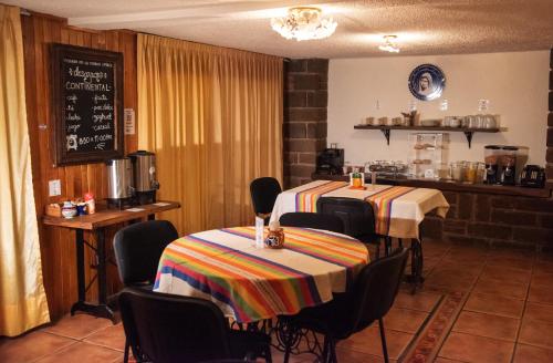 een restaurant met 2 tafels en stoelen en een schoolbord bij Posada de la Virgen in Tlaxcala de Xicohténcatl