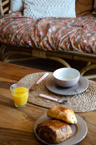 - une table avec des assiettes de nourriture et un bol de jus d'orange dans l'établissement SAVANNAH, à Saint-Malo