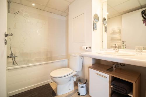 a white bathroom with a toilet and a sink at L'ETHNIK--STUDIO TOUT CONFORT--CLIM--PARKING--WIFi in Lourdes