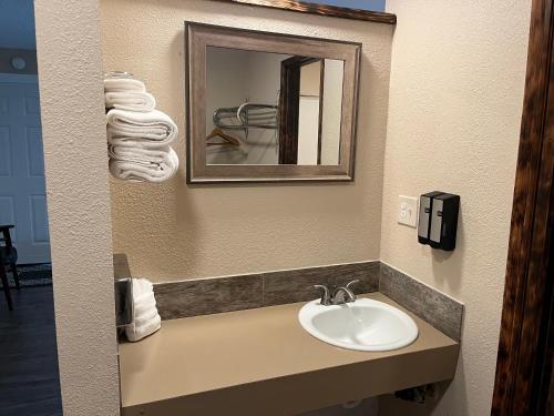 a bathroom with a sink and a mirror and towels at Heidi's Inn in Ilwaco