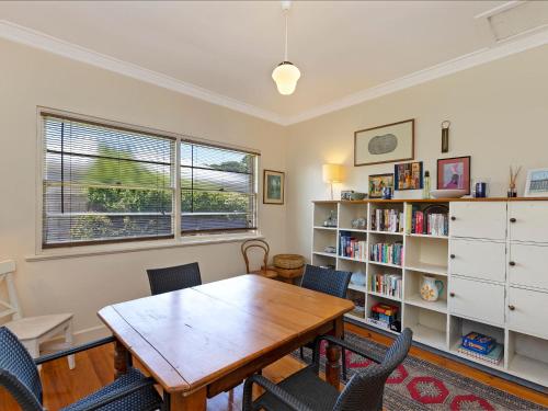 a dining room with a table and chairs and a book shelf at 40 Campbell in Port Fairy