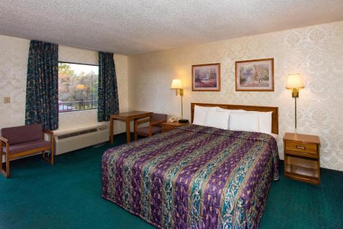 una camera d'albergo con letto e finestra di Express Inn Eureka Springs a Eureka Springs