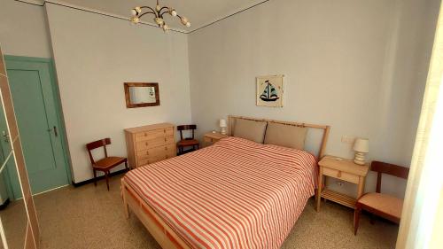 レヴァントにあるAppartamento Galli al mareのベッドルーム1室(ベッド1台、椅子2脚、ドレッサー付)
