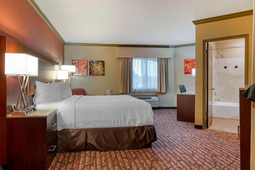 a hotel room with a bed and a bathroom at Best Western Plus Brookside Inn in Milpitas