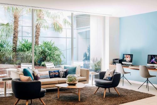 a living room with a couch and two chairs at Saint Kilda Beach Hotel - formerly Rydges St Kilda in Melbourne