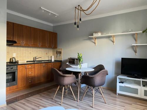 a kitchen with a table and chairs and a television at Apartmán Pošta in Rajecké Teplice