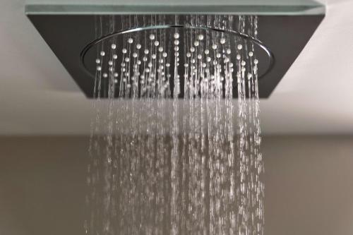 a shower head with a glass shower curtain at Yotel San Francisco in San Francisco