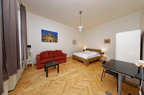 sala de estar con sofá rojo y cama en Peter's Tower Apartments, en Praga