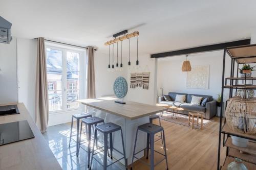 cocina y sala de estar con mesa y taburetes en Villa des Arts en Épernay