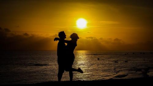 a man and woman dancing on the beach at sunset at POUSADA CENÁRIO IDEAL in Icapuí