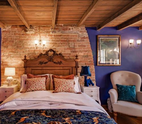 a bedroom with a bed and a brick wall at Historic Hidden Gem-10mins walk to Holmfirth, Log Burner,Easy Parking in Holmfirth