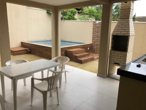 patio ze stołem i krzesłami oraz basenem w obiekcie Pousada Recanto Lajeado w mieście Lajeado
