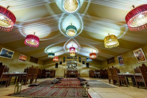 a room with tables and chairs and colorful lights at Agafay Pearl Camp Marrakech in Marrakech