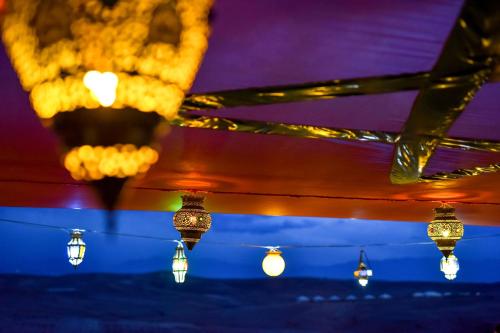 a bunch of lights hanging from a ceiling at Agafay Pearl Camp Marrakech in Marrakech
