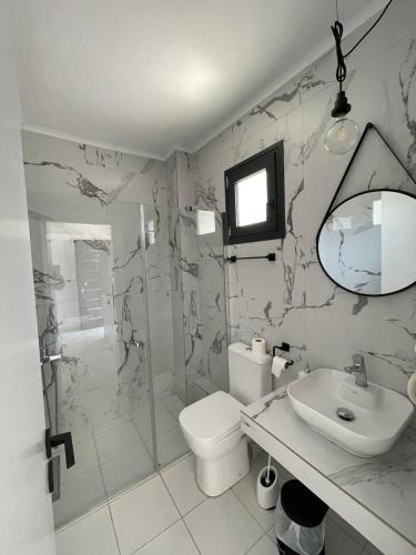 a bathroom with a toilet and a sink and a shower at Pine Resort in Polychrono
