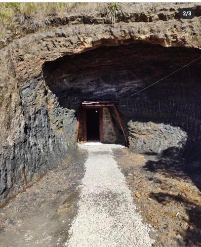 a tunnel with a door in a rock cave at Entre Rocas y Cristales in Ráquira