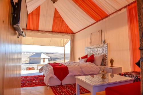 a bedroom with a bed and a large window at Agafay Pearl Camp Marrakech in Marrakech